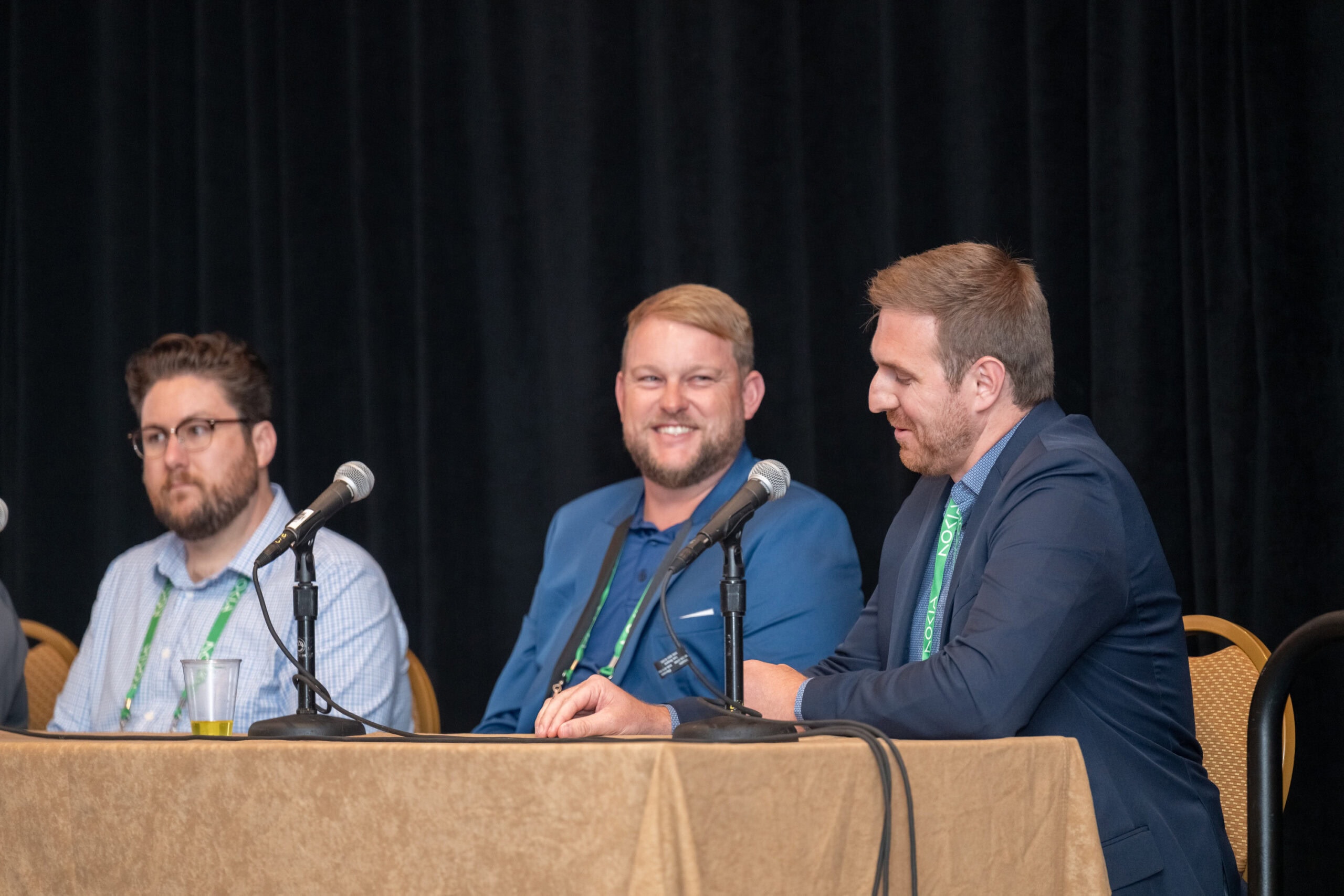 Three panelists in front of microphones